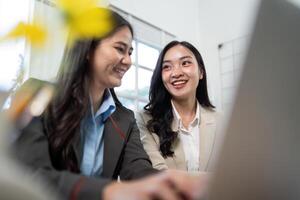 Engaging Discussion. Two businesswomen sharing insights while working on a laptop. photo