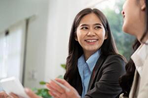 Positive Interaction and Teamwork. Smiling businesswoman engaging in conversation with colleague. photo