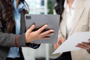 Digital Transformation in Business. Professionals reviewing data on a tablet during a meeting. photo