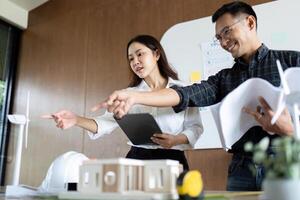 Sustainability and Engineering. Engineers pointing out features of eco-friendly designs in a collaborative setting. photo