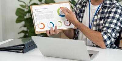 Data Presentation. Young man explaining charts during a business meeting in a home office. photo