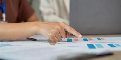 Data Analysis and Strategy. Professional pointing at financial graphs during a team meeting. photo