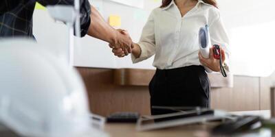 Sustainability in Engineering. Engineers shaking hands over eco-friendly project agreement. photo