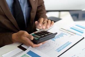 Financial Reporting. Businessman calculating data with a financial calculator. photo