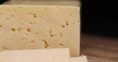 a piece of semi-hard cheese with holes in place of slicing for cooking photo