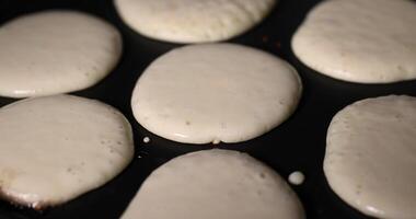 baking pancakes with butter in a frying pan close up, hot metal pan while cooking pancakes photo