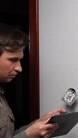 A man is holding a tablet computer and looking at it video