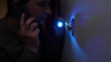 A man is talking on a cell phone while holding a flashlight video