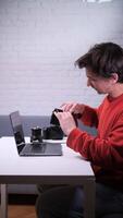 A man sitting at a table with a laptop and camera. empty wallet, finance crisis, pay bill video