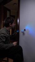 vertical Electrician illuminates a light switch with a uv light, revealing potential electrical problems within the wall, showcasing the importance of professional electrical inspections video