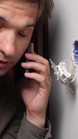 A man talking on a cell phone while holding a screwdriver video
