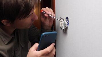 A man is using a screwdriver to fix a hole in a wall video