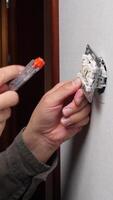 A person is using a screwdriver to fix a light switch video