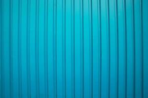 Vertical ridged blue metal surface with subtle shadows, ideal for industrial or architectural backgrounds. photo