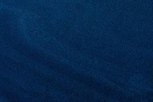 Fine-grain dark blue sand texture with subtle gradients, ideal for backgrounds and design overlays. photo