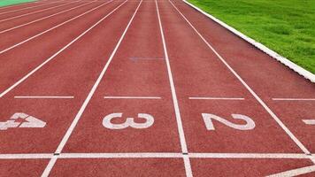 Red running track with numbered starting lines outdoor. video