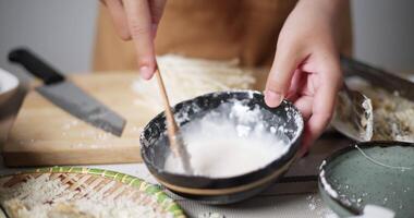 Handheld selective focus shot, A woman's hands is mixing batter and other ingredients to prepare fried food. Woman cooking at home. Food preparation. video
