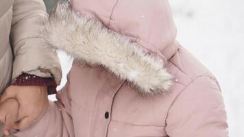 Kid in pink coat enjoys winter snow in a cozy neighborhood video