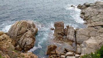 A rocky coastline with waves crashing against the rocks video