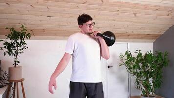 man training with kettlebell at home while working from the computer from home video