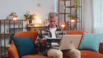 Stressed man freelancer reviewing business charts and graphs and throwing papers unpaid bills in air video