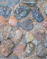 Old stone pavement vertical backgdrop, close up of large gray cobblestones. Perfect for abstract wall art, interior or exterior design, or nature inspired concepts photo