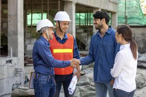 Newly wed couple is handshaking with engineering contractor at the under construction house to inspect building progress and quality control for home ownership and real estate development photo