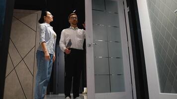 Consultant showing door to couple in furniture store video