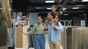 Family choosing tiles in hardware store with consultant video