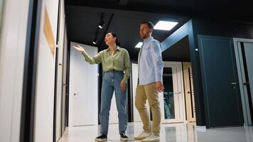 Consultant showing door and tiles options to couple in showroom video