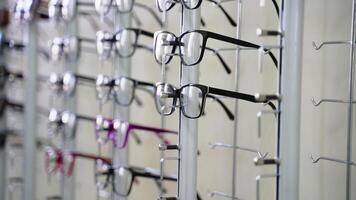 Eyeglasses display stand in optical store showing different eyeglass frames video