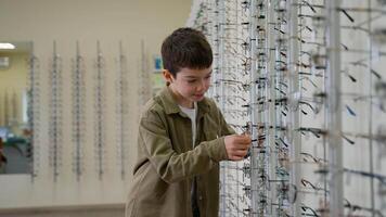 Child choosing eyeglasses in optical store video