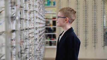 Happy child choosing eyeglasses, smiling and giving thumbs up video