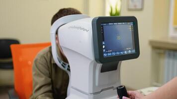Optometrist examining patient's eye with autorefractor in ophthalmology clinic video