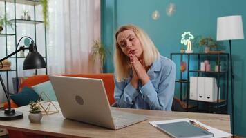 Upset woman with hands joined at web camera of laptop compute asking more time for task completion video