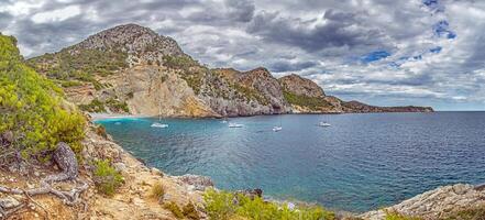 Cala San Vincenc bay with yachts and cliffs photo