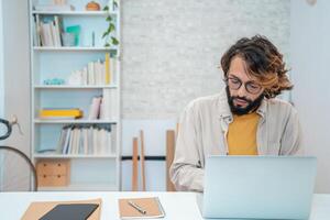 Man using laptop at home remote work in a small business with copy space. photo