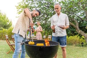 Multiethnic middle-aged people cooking with the barbecue smiling happy and laughing together photo