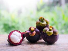 A ripe mangosteen on wooden table. Queen of fruits in Thailand photo