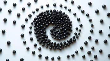 Abstract arrangement of black spheres creating a hypnotic spiral pattern on a white background, conveying a sense of depth, order, and visual appeal, ideal for artistic and design projects. photo