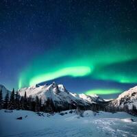 Green and Blue Aurora Borealis over Snowy Mountain Range at Night photo
