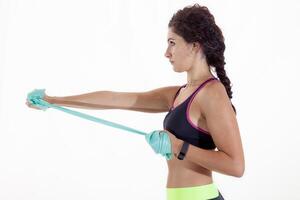 beautiful sportswoman in profile doing exercises with rubber bands isolated on white background photo