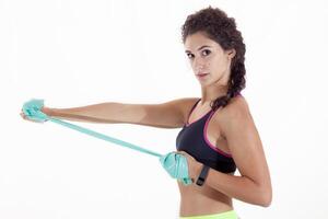 pretty sporty girl in profile looking into the camera doing exercises with rubber bands photo
