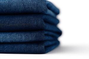 Dark blue jeans are neatly folded in a stack, highlighting their rich color and smooth texture. They are perfect for casual outfits and fashionable styles all year round. photo