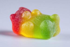 A vibrant gummy bear candy lies on its back, showcasing a rainbow of colors including red, yellow, and green. Its sugary texture glistens under soft light, making it an appealing treat. photo