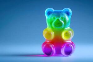 A vibrant gummy bear, featuring a rainbow of colors, sits on a smooth surface with a blue backdrop. The candys playful shape and glossy texture create an eye-catching visual delight. photo