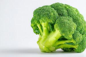Close-up view of fresh broccoli with bright green florets and crisp stems. This nutritious vegetable stands against a plain background, emphasizing its rich color and freshness. photo