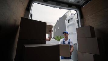 Two young workers of removal company unload boxes from minibus into customer's home 7 video