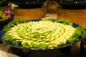 Cucumber platter Buffet meal consisting of vegetables and cucumber slices and chili sauce served in plastic wrap at an event photo