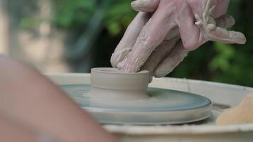 Close up of hands working with clay on a potter's wheel. Craftsman shapes a clay product on a potter's wheel video